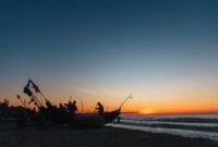 Seorang nelayan melintasi perairan dangkal dengan perahu kayu tradisional saat matahari terbit di kawasan pesisir Indonesia. Aktivitas harian ini memperlihatkan keharmonisan antara manusia dan laut yang terus terjaga secara turun-temurun.