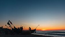 Seorang nelayan melintasi perairan dangkal dengan perahu kayu tradisional saat matahari terbit di kawasan pesisir Indonesia. Aktivitas harian ini memperlihatkan keharmonisan antara manusia dan laut yang terus terjaga secara turun-temurun.