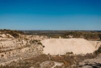 Pemandangan udara kawasan pertambangan terbuka yang menunjukkan perbukitan terkelupas dan pengerukan lahan masif untuk memenuhi permintaan mineral global.