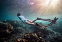 Seorang penyelam lokal dengan cermat merawat fragmen karang baru pada media transplantasi bawah laut sebagai bagian dari upaya restorasi ekosistem pesisir di perairan Nusantara.