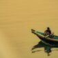 Seorang nelayan tradisional menyiap jaringan perahu kayunya di pesisir pantai Indonesia saat matahari terbenam. Kehidupan masyarakat pesisir tetap menyatu erat dengan ritme alam dan laut Nusantara.