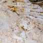Pemandangan kawah bekas galian tambang terbuka yang mengubah lanskap hutan tropis hijau menjadi bentang tanah gersang dan genangan air asam beracun di pedalaman Indonesia.