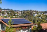 Instalasi panel surya pada atap rumah di kawasan perkotaan yang memanfaatkan sinar matahari sebagai energi alternatif ramah lingkungan.