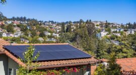 Instalasi panel surya pada atap rumah di kawasan perkotaan yang memanfaatkan sinar matahari sebagai energi alternatif ramah lingkungan.