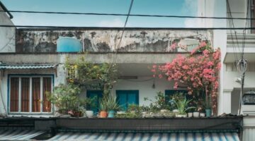 Sebuah hunian perkotaan yang menerapkan konsep hemat energi dengan memanfaatkan tanaman hijau di area balkon serta panel surya atap untuk meredam suhu panas ruangan secara alami.