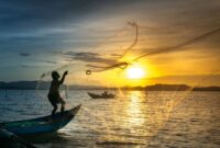 Seorang nelayan tradisional di perairan Nusantara sedang menggunakan teknik pancing ulur yang ramah lingkungan untuk menjaga kelestarian populasi ikan laut.