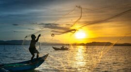 Seorang nelayan tradisional di perairan Nusantara sedang menggunakan teknik pancing ulur yang ramah lingkungan untuk menjaga kelestarian populasi ikan laut.