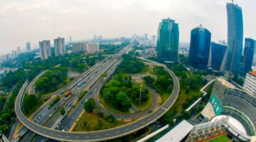 Seorang warga menikmati ruang terbuka hijau di tengah kawasan perkotaan yang rindang sebagai bagian dari penyesuaian gaya hidup ramah lingkungan menghadapi suhu udara yang semakin meningkat.