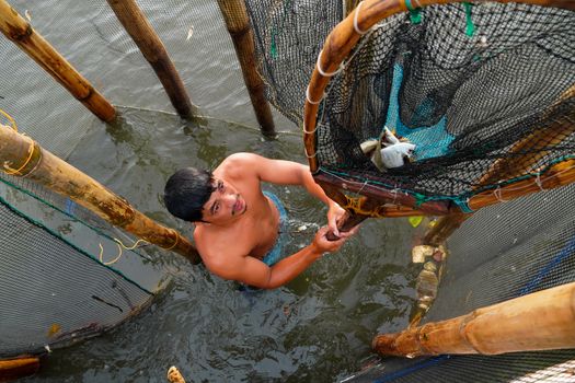 Seorang nelayan tradisional di perairan Maluku menggunakan metode pancing ulur yang ramah lingkungan untuk menjaga populasi ikan laut.