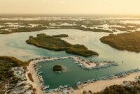 Sejumlah wisatawan berjalan menyusuri jembatan kayu di tengah rindangnya kawasan ekowisata mangrove pesisir yang kini menjadi benteng hijau pelindung pantai sekaligus destinasi liburan berkelanjutan.
