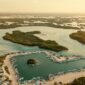 Sejumlah wisatawan berjalan menyusuri jembatan kayu di tengah rindangnya kawasan ekowisata mangrove pesisir yang kini menjadi benteng hijau pelindung pantai sekaligus destinasi liburan berkelanjutan.