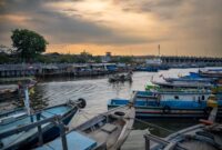 Para nelayan di desa pesisir bersiap melaut menggunakan perahu kayu tradisional saat matahari terbit melukis cakrawala pagi.