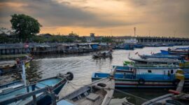 Para nelayan di desa pesisir bersiap melaut menggunakan perahu kayu tradisional saat matahari terbit melukis cakrawala pagi.