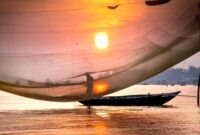 Seorang nelayan tradisional di perairan pesisir Indonesia menggunakan metode pancing ulur yang ramah lingkungan untuk menjaga kelestarian populasi ikan dan ekosistem terumbu karang.