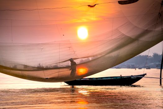 Seorang nelayan tradisional di perairan pesisir Indonesia menggunakan metode pancing ulur yang ramah lingkungan untuk menjaga kelestarian populasi ikan dan ekosistem terumbu karang.