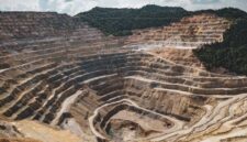 Pemandangan udara bekas galian tambang terbuka yang mengikis kawasan hijau pesisir, memperlihatkan dampak nyata industri ekstraktif terhadap lanskap alam Indonesia.