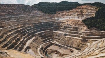 Pemandangan udara bekas galian tambang terbuka yang mengikis kawasan hijau pesisir, memperlihatkan dampak nyata industri ekstraktif terhadap lanskap alam Indonesia.