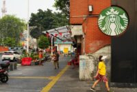 Warga perkotaan berjalan di bawah terik matahari ekstrem sembari menerapkan kebiasaan ramah lingkungan seperti membawa botol minum ulang pakai untuk mengurangi limbah plastik di tengah krisis iklim.